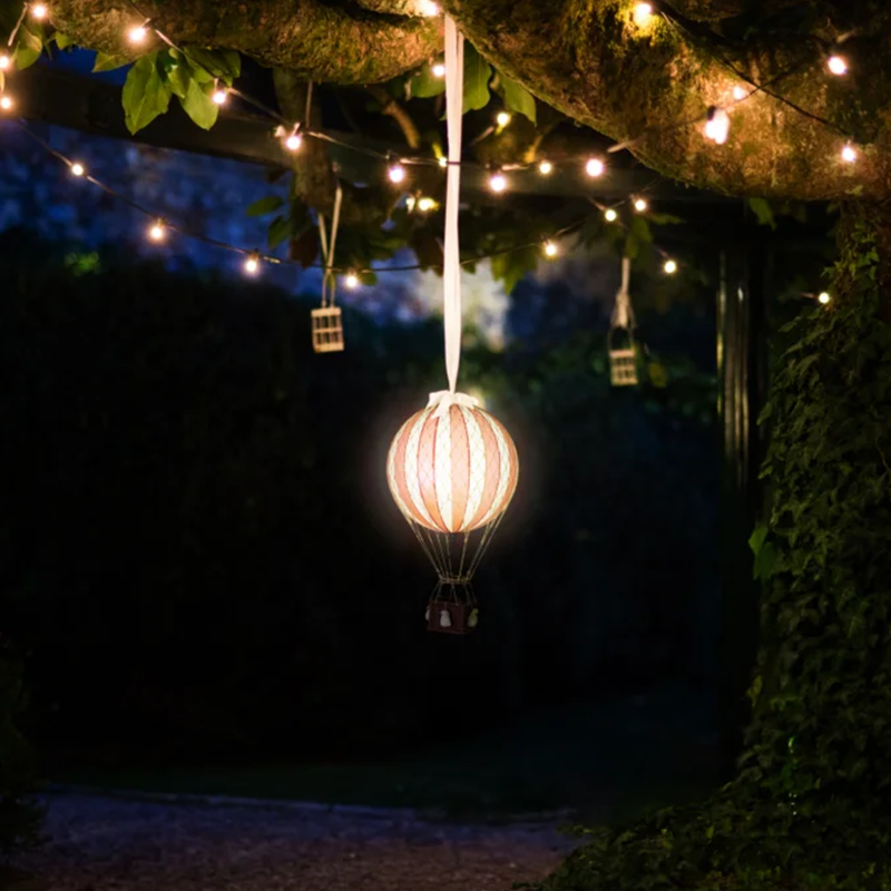 Leuchtender Deko LED-Heissluftballon mit roten und weissen Streifen von Authentic Models, der an einem Ast hängt.