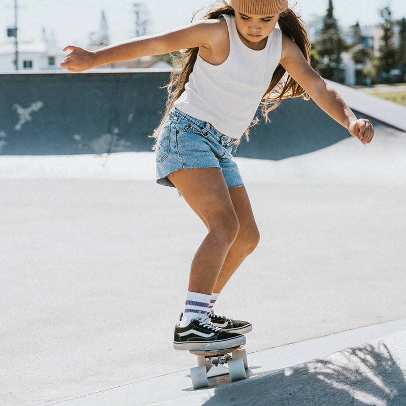 Banwood Skateboard Mint, mit Mädchen das darauf fährt