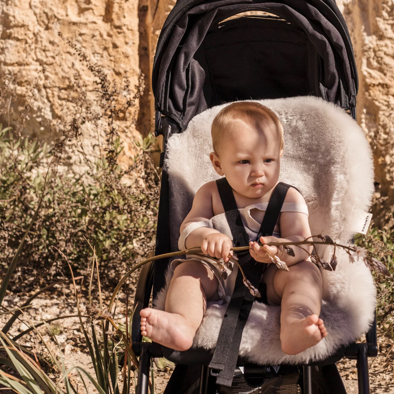 Kind in schwarzem Buggy mit Schaffell-Sitzauflage