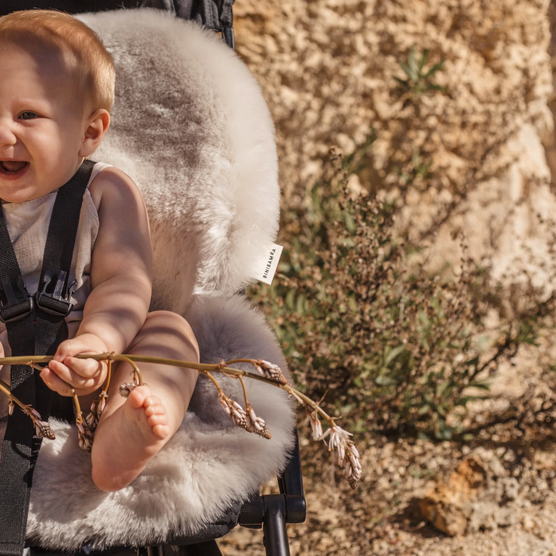 Kind in Buggy mit hellgrauer Schafffell-Sitzauflage