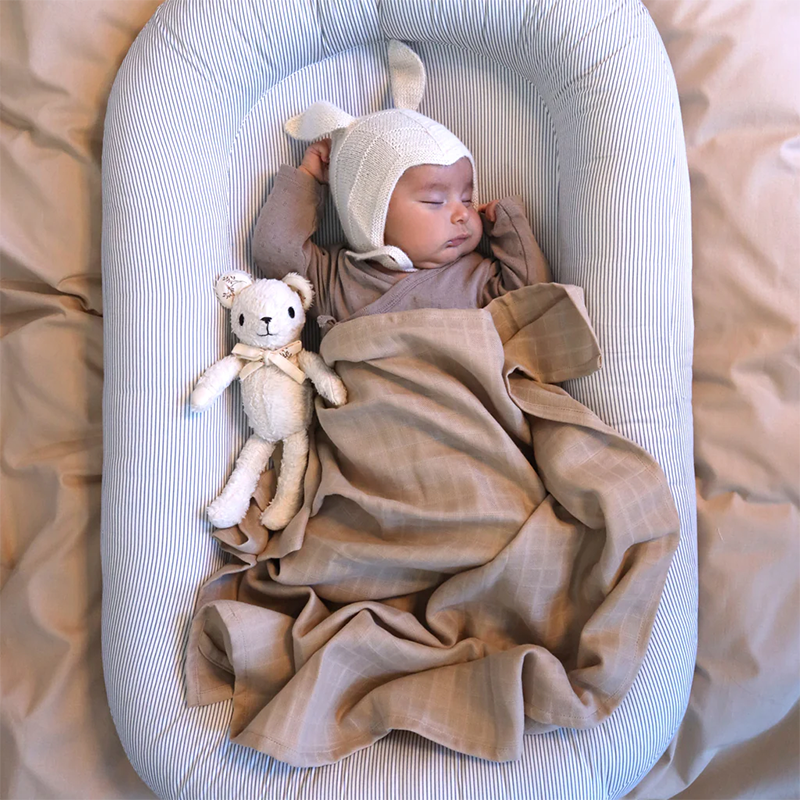 Baby liegt im Babynest Classic Blue Stripes von Cam Cam Coopenhagen. 
