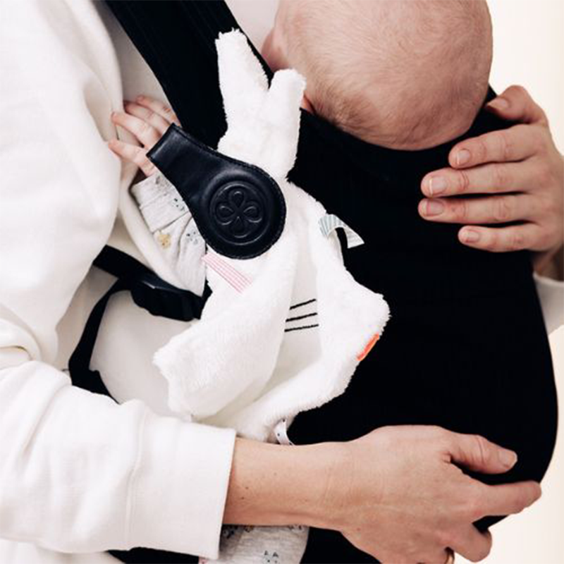 Kuscheltuch befestigt mit Magnetclip von Cloby an der Babytrage befestigt.