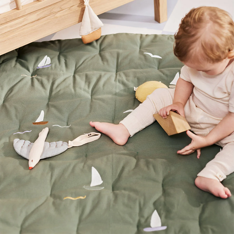 Kind spielt auf der Dear April Spielmatte Sailboats.