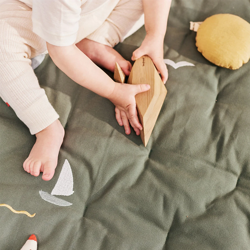 Kind spielt auf der Dear April Spielmatratze Sailboats. 