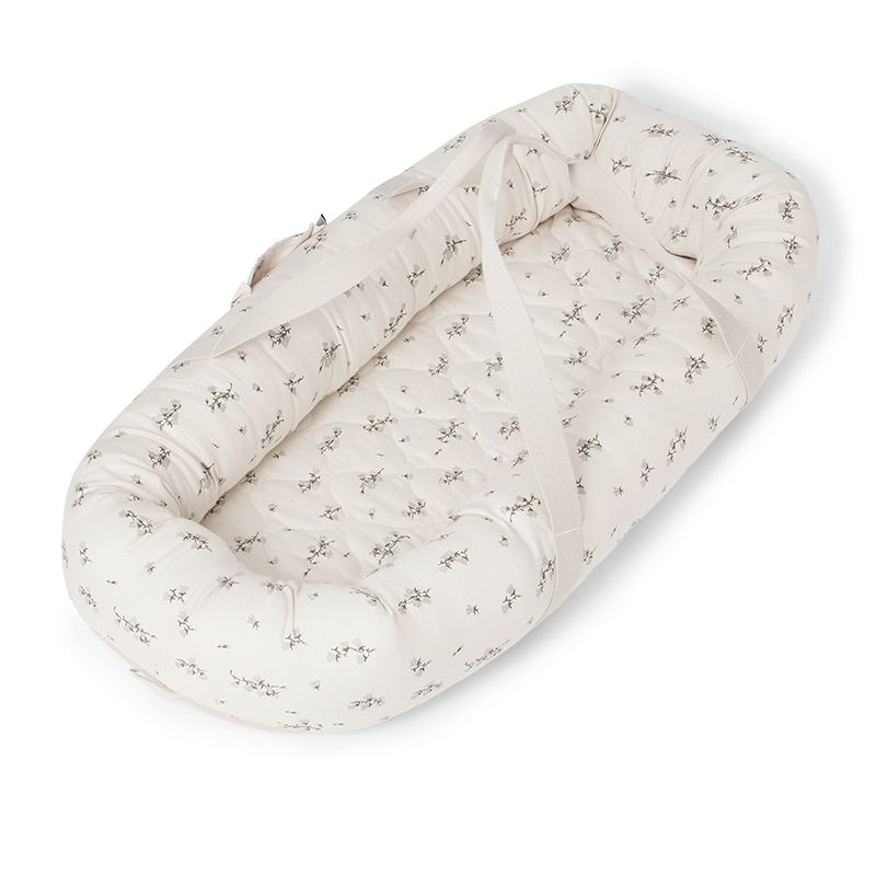 Babynest in Weiss mit dezentem Blau-grünem Blumenprint von Garbo&Friends.