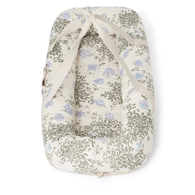 Babynest in Beige mit Tragegriffen und blau-grünem Blumenmuster von Garbo&Friends.