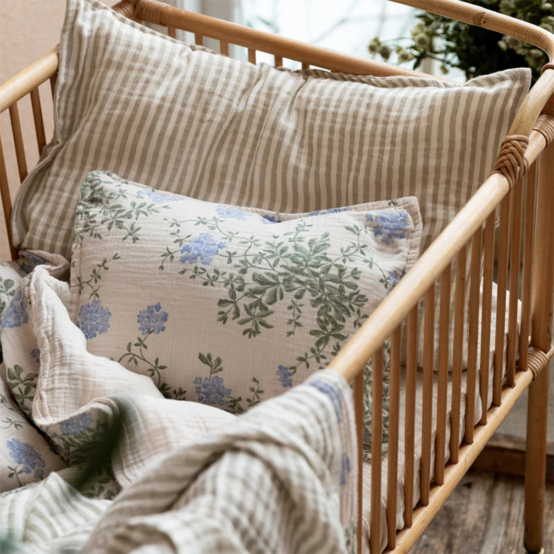 Bettwäsche-Set Junior in Beige mit sanftem Blumen- und Blättermuster von Garbo & Friends in einem Kinderbett.