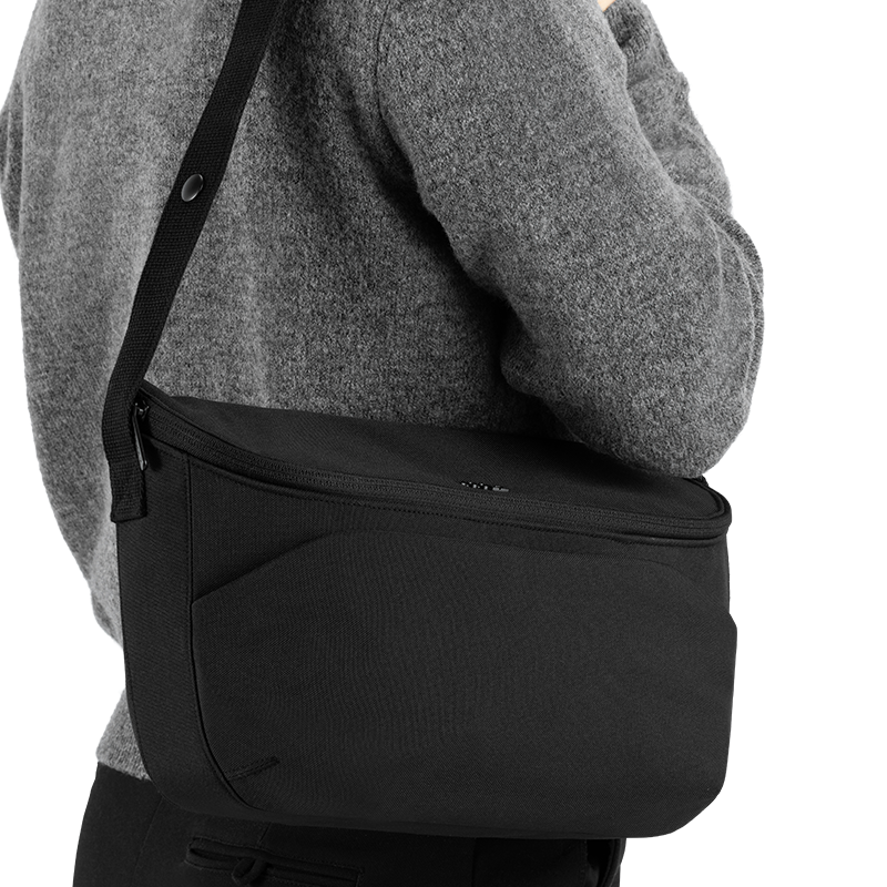 Joolz Kinderwagen Organiser in Schwarz über Schulter gehängt. 