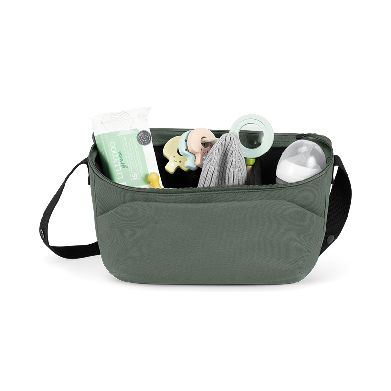 Offener Kinderwagen Organizer in Dunkelgrün mit schwarzem Henkel gefüllt mit Flasche, Feuchttücher, und Babyspielzeug von Joolz. 
