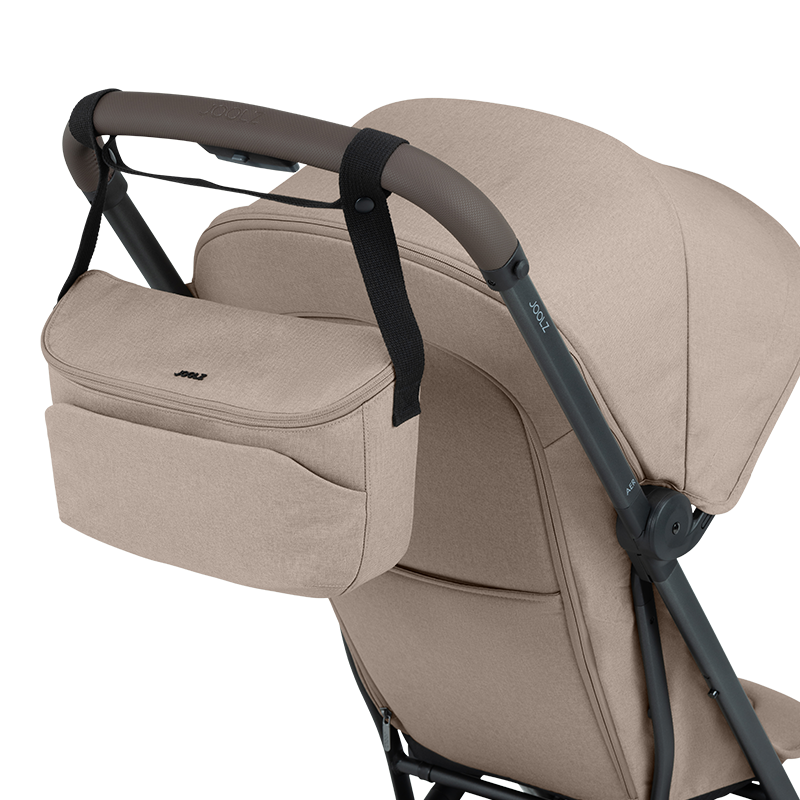 Kinderwagen Organizer in Beige mit schwarzem Henkel von Joolz am Kinderwagen angehängt. 