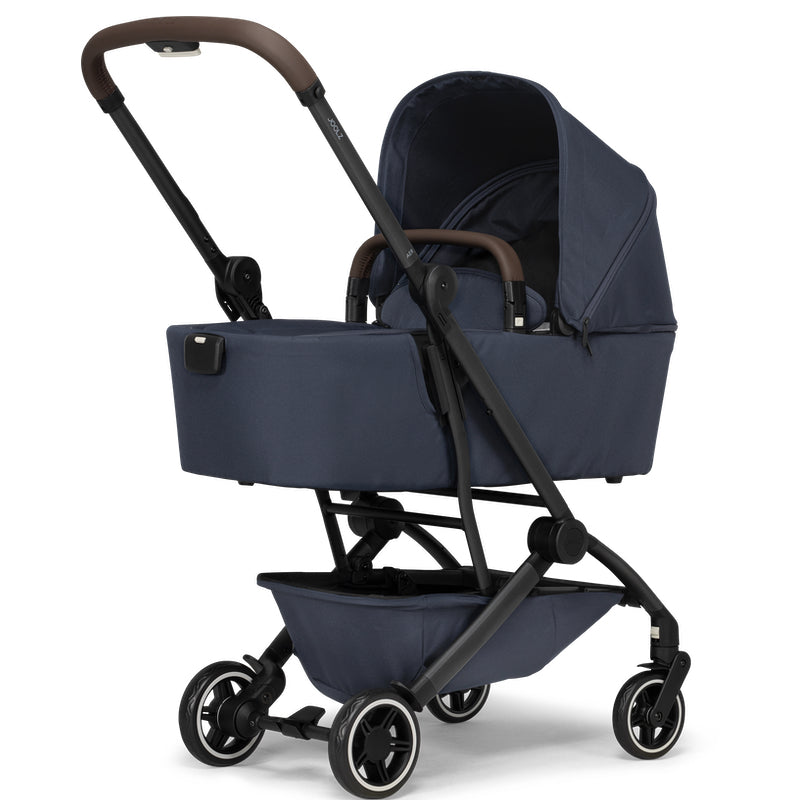 Blaue Jooz Aer+ Babywanne aufgestellt auf Gestell mit braunem Leder griffen