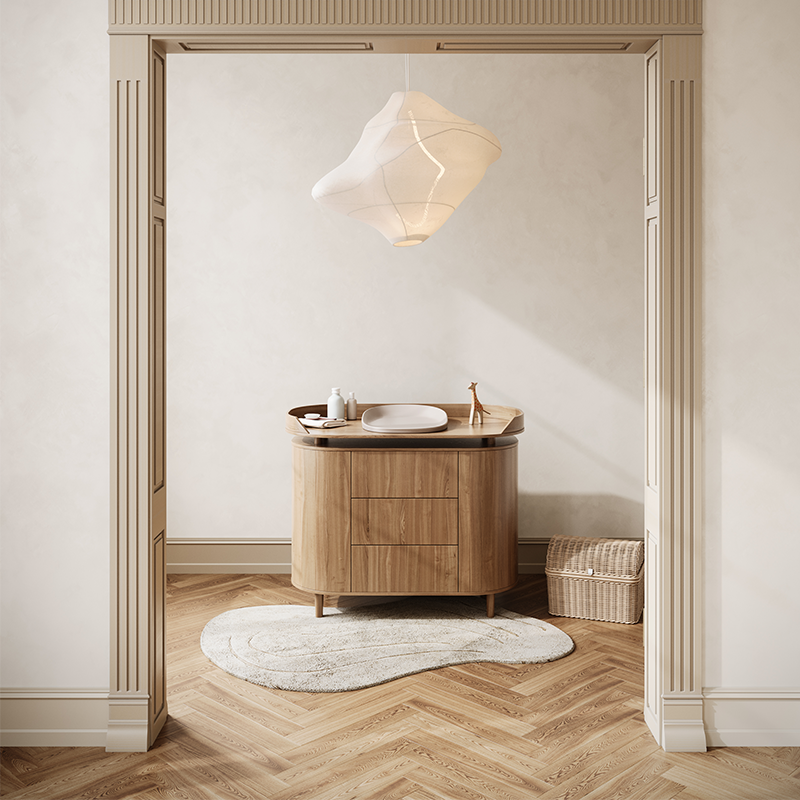Wickelkommode mit Wickelunterlage steht in einem Zimmer.