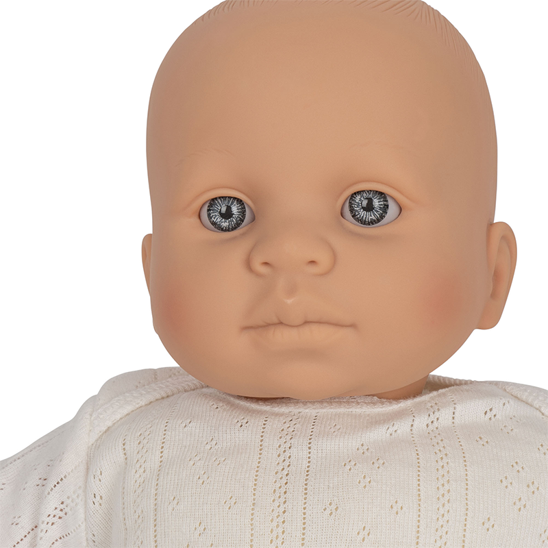 Nahaufnahme von Puppe mit weissem Pyjama von Konges Slojd.