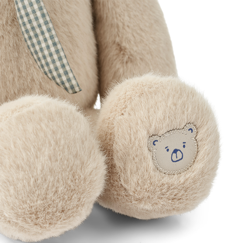 Nahaufnahme vom Fuss mit Bärenstickerei vom Kuscheltier Hase in Beige von Liewood.
