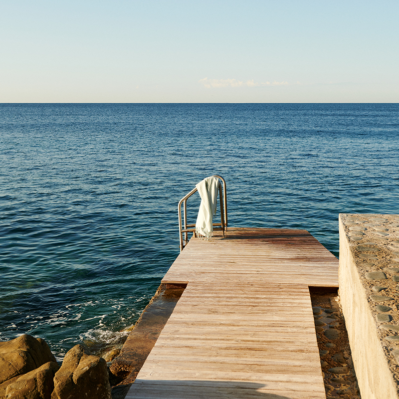 Liewood Strandtuch mit Streifen in Blau und Weiss und Fransen am Strand.