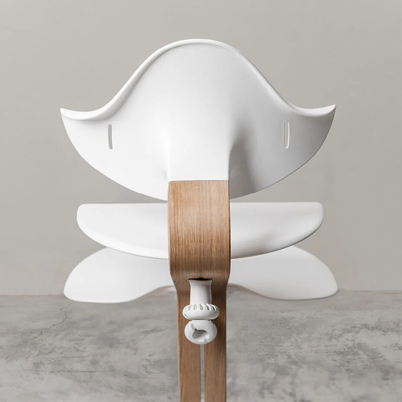 Nomi Hochstuhl mit Mittelbalken aus Holz und Sitz, Rückenlehne, und Füsse in Weiss von Stokke von hinten.