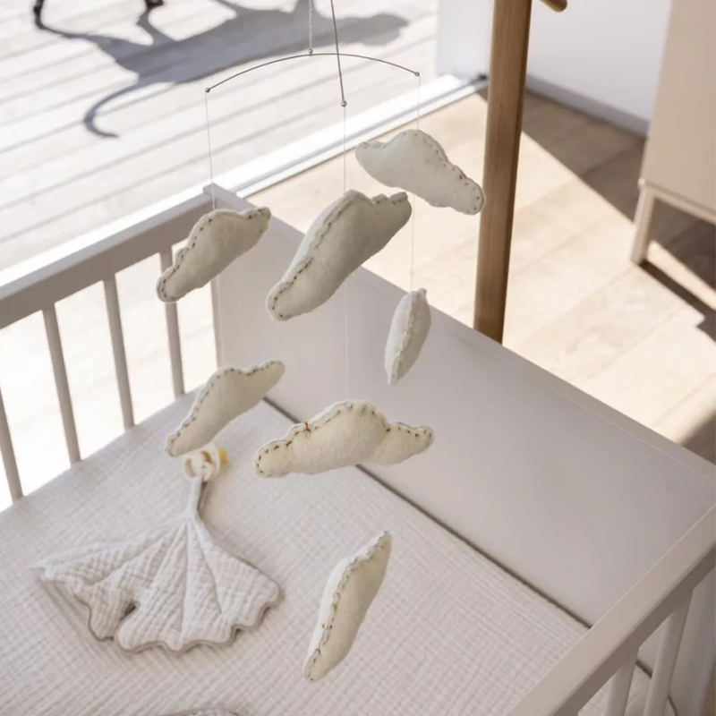 Wolkenmobile an einem Mobileständer von Quax über einem Babybett.