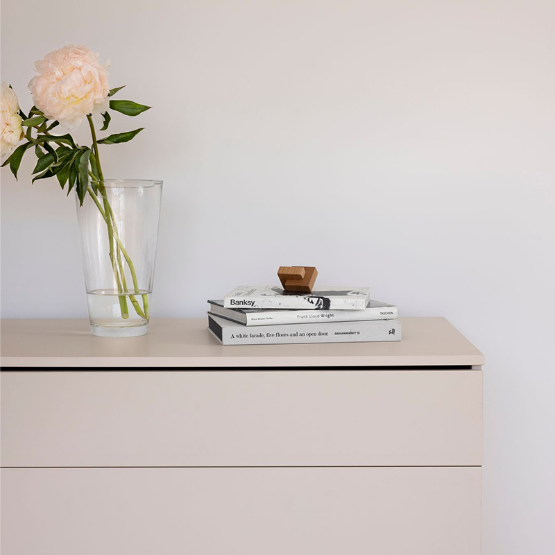 Kommode in hellem grau-beige mit Blumen  und Bücher drauf von Quax.