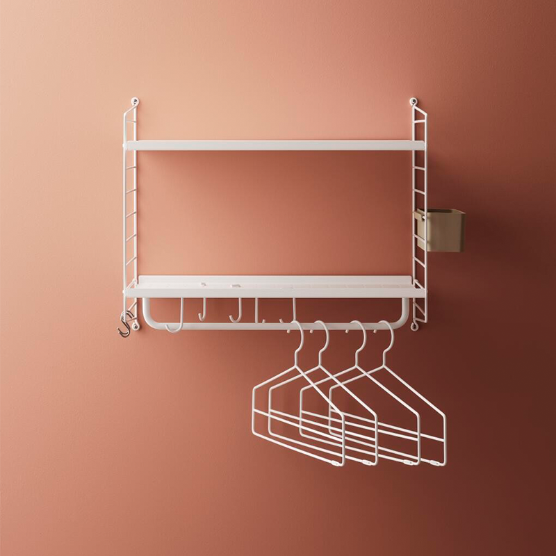 String Furniture Wandregal in Weiss. Im unteren Regalboden sind Haken eingehängt für Jacken und Taschen. 