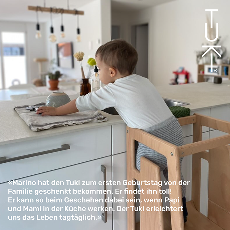Junge spielt in der Küche auf dem Tuki Lernturm Natur aus Buchenholz.