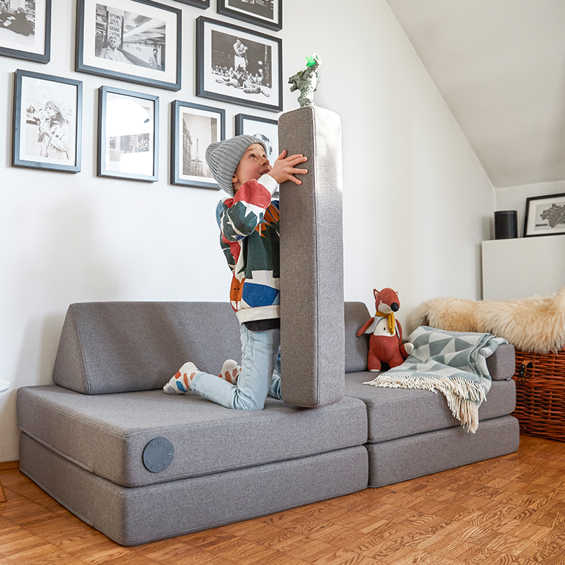 Wonderwuzz modulares Spielsofa 'OH SO SOFY' in der Farbe Grauffelo mit Kind, das damit spielt.
