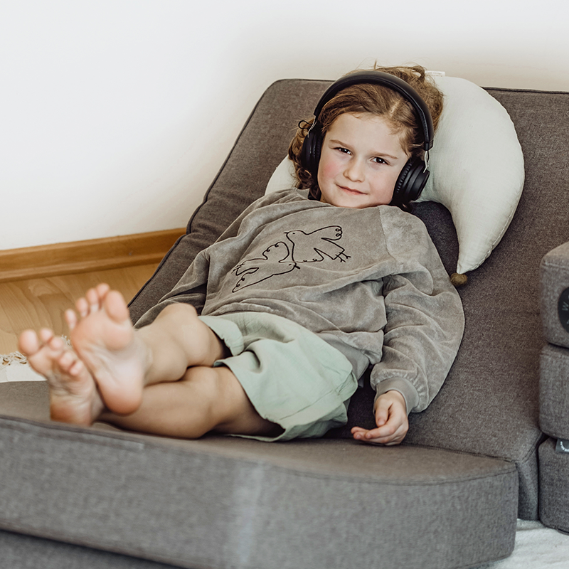 Wonderwuzz modulares Spielsofa 'OH SO SOFY' in der Farbe Grauffelo als Sessel angeordnet, auf dem ein Junge sitzt. 