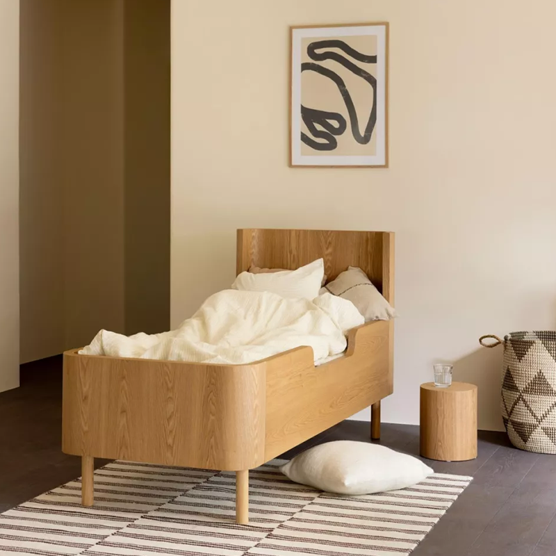 Juniorbett aus Eschenholz von Quax steht in einem Kinderzimmer. 